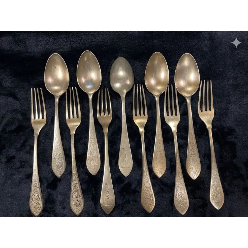 A breathtaking testament to mid-20th-century Persian metalwork, this antique 10-piece flatware service features 5 dessert/place spoons and 5 matching forks